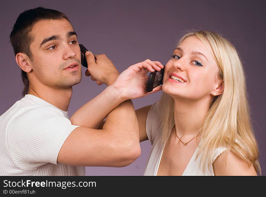 The guy and the girl with mobile phone on a grey background