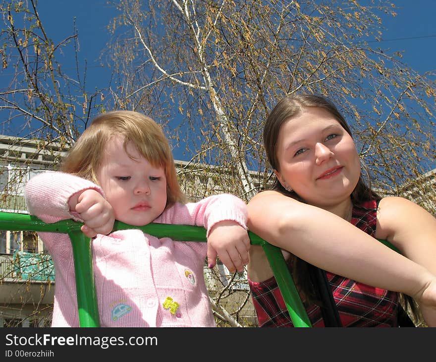 Portrait of girl and her small sister against the background of the tree. Portrait of girl and her small sister against the background of the tree