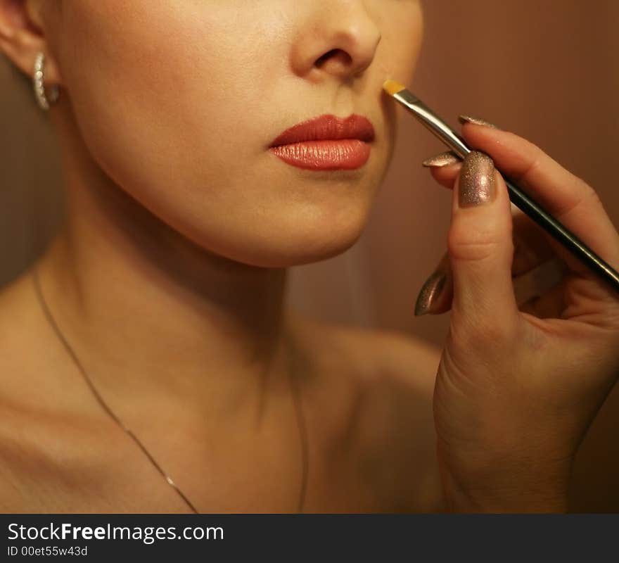 Part of the beautiful face of the girl and hand with a brush. Part of the beautiful face of the girl and hand with a brush