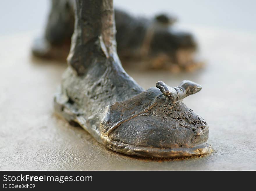 Photo of a Statues Brass Boot. Focus on bow.