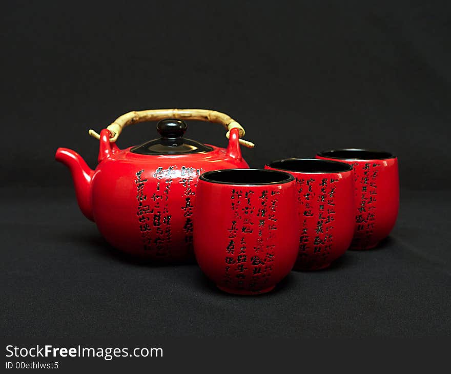 Red Chinese teapot with cups for tea leaves of green tea