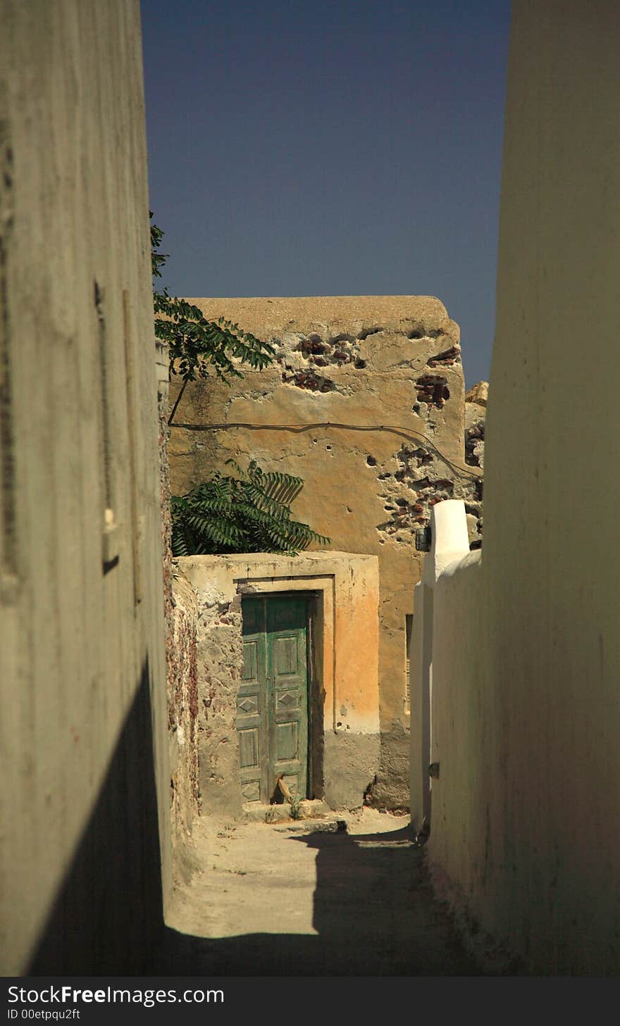 Greek passageway going down towards an old green door