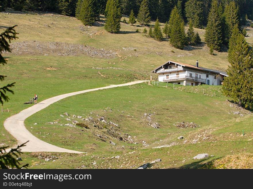 Mountain-biker on the road near bavarian home.