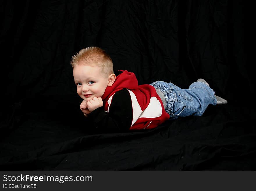 Cute little boy on black background