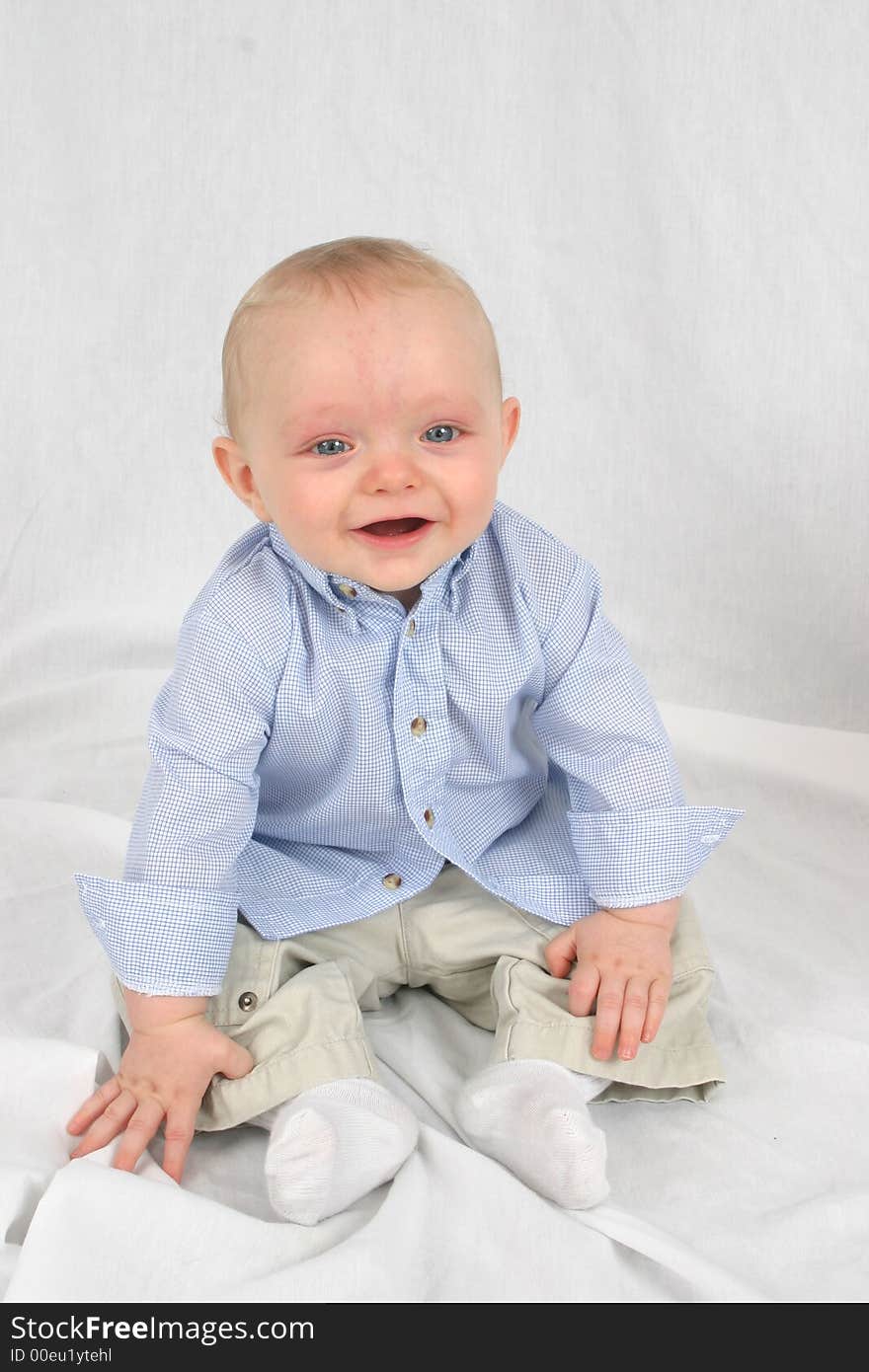 Cute little boy sitting in a white background