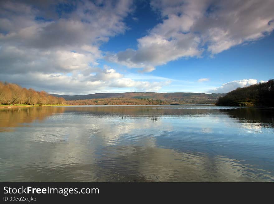 Beautiful shoreline view with sky reflexions in water and spring colors