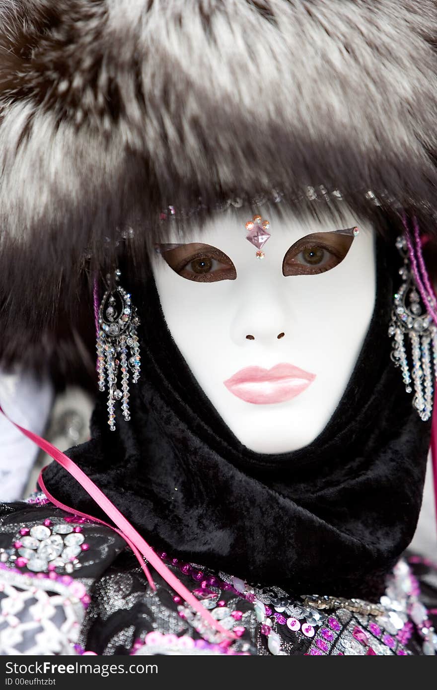 Lady at the Venice Carnival wearing a fox hair hat, jewelery and a white mask. Lady at the Venice Carnival wearing a fox hair hat, jewelery and a white mask