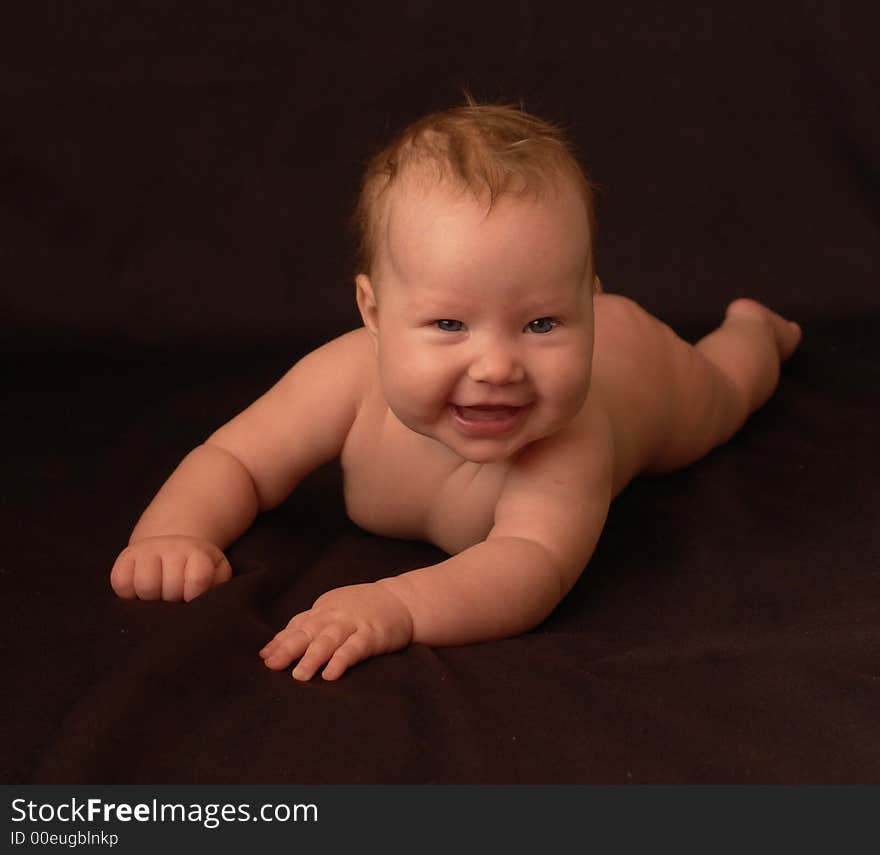 Little smiling baby on the background black. Little smiling baby on the background black