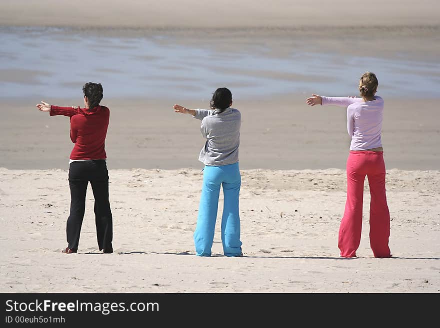 Three girls in the beach relaxing (arms left)