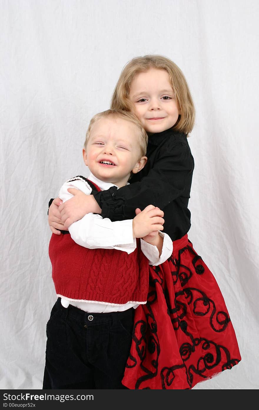 Brother and sister hugging on a white background