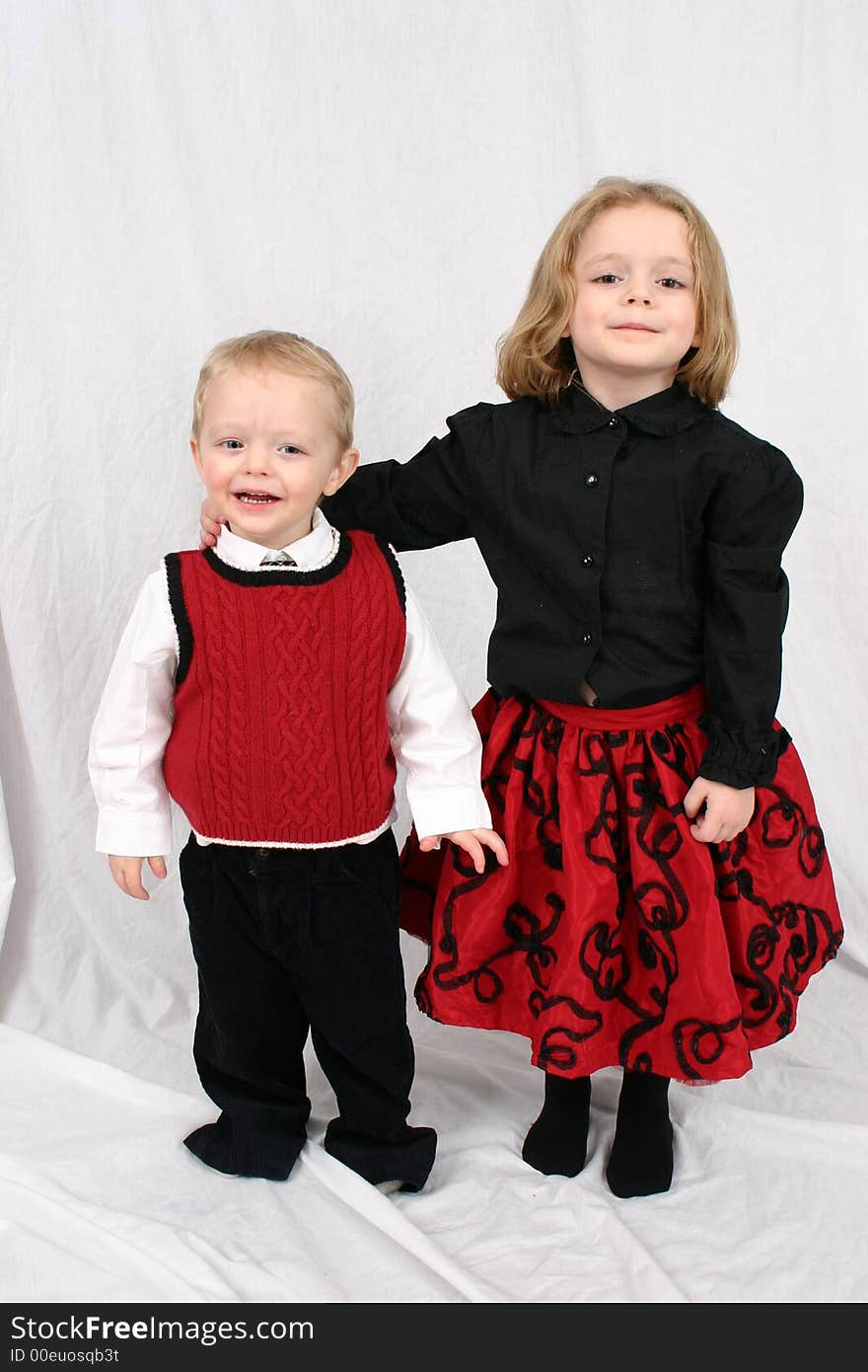 Brother and sister hugging on a white background