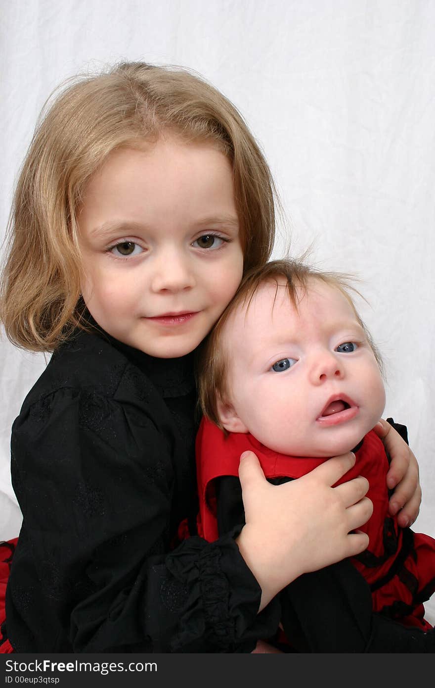 Sisters sitting together on a white background