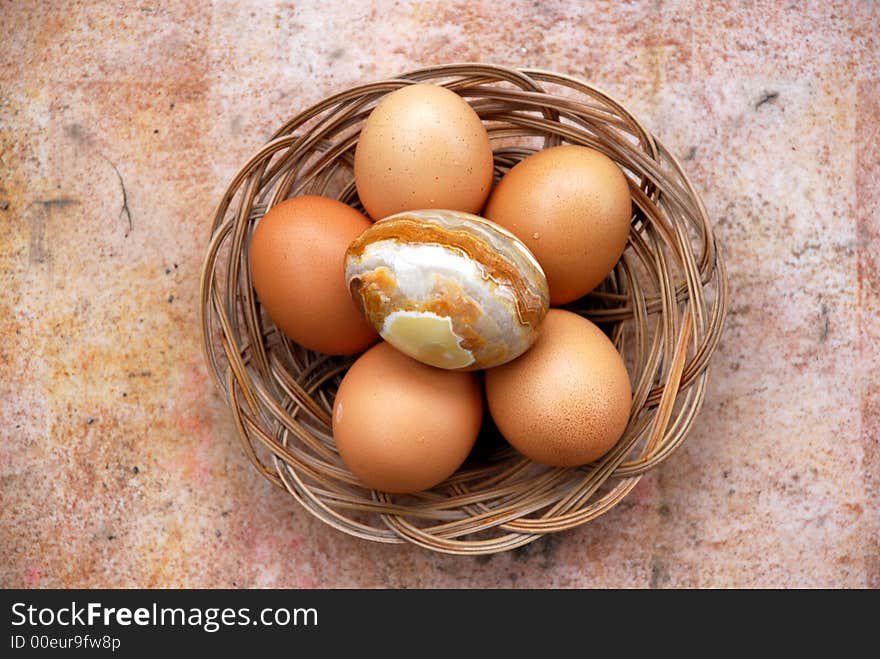 Basket with brown eggs and one onix egg view from above. Basket with brown eggs and one onix egg view from above