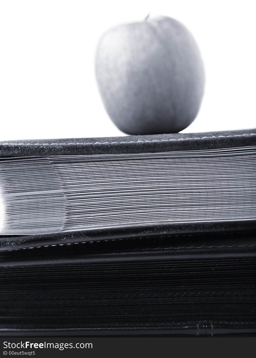 Black and white apple on top of books. Black and white apple on top of books.