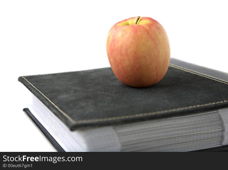 Pink lady apple on top of binder. Pink lady apple on top of binder