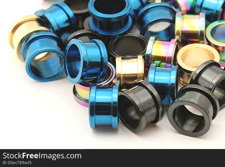 A big pile of colorful titanium on flesh tunnels. These are used in stretched ear lobes. A big pile of colorful titanium on flesh tunnels. These are used in stretched ear lobes.