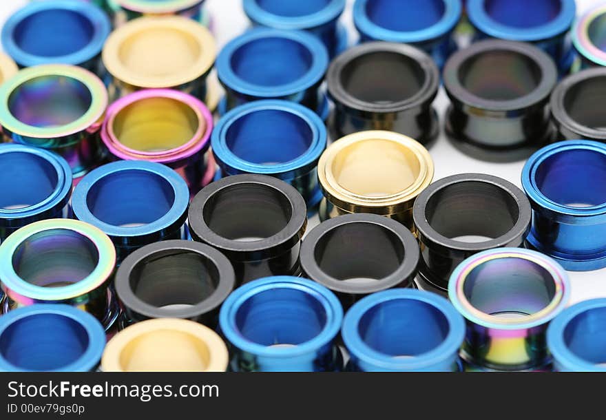 A big pile of colorful titanium on flesh tunnels. These are used in stretched ear lobes. A big pile of colorful titanium on flesh tunnels. These are used in stretched ear lobes.