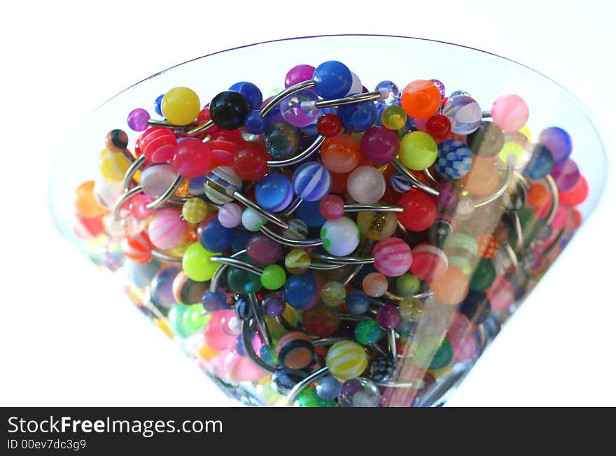 A martini glass full of navel rings. A martini glass full of navel rings