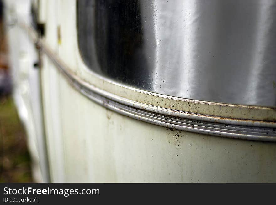 The curved window of a streamlined travel trailer of the late sixties showing deterioration, shallow DOF. The curved window of a streamlined travel trailer of the late sixties showing deterioration, shallow DOF.