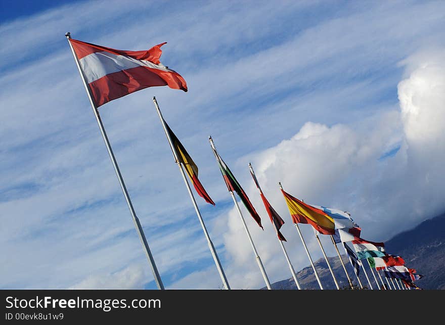 A row of european national flags with blue sky and clouds on background