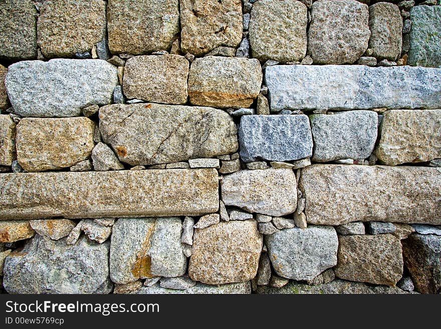 Colorful and textured stone masonry wall useful for backgrounds
