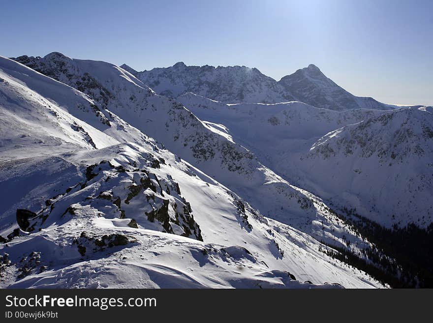 High mountain covered with snow in sunny winter day