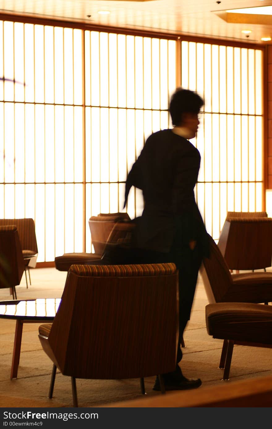 Man passing through lounge with japanese rice wall. Man passing through lounge with japanese rice wall