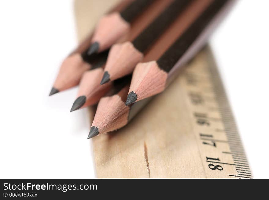 Sharp pencils and ruler on white background with narrow DOF