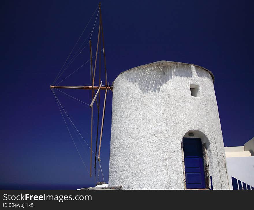 Whitewashed windmill in Santorini against a bright blue sky. Whitewashed windmill in Santorini against a bright blue sky