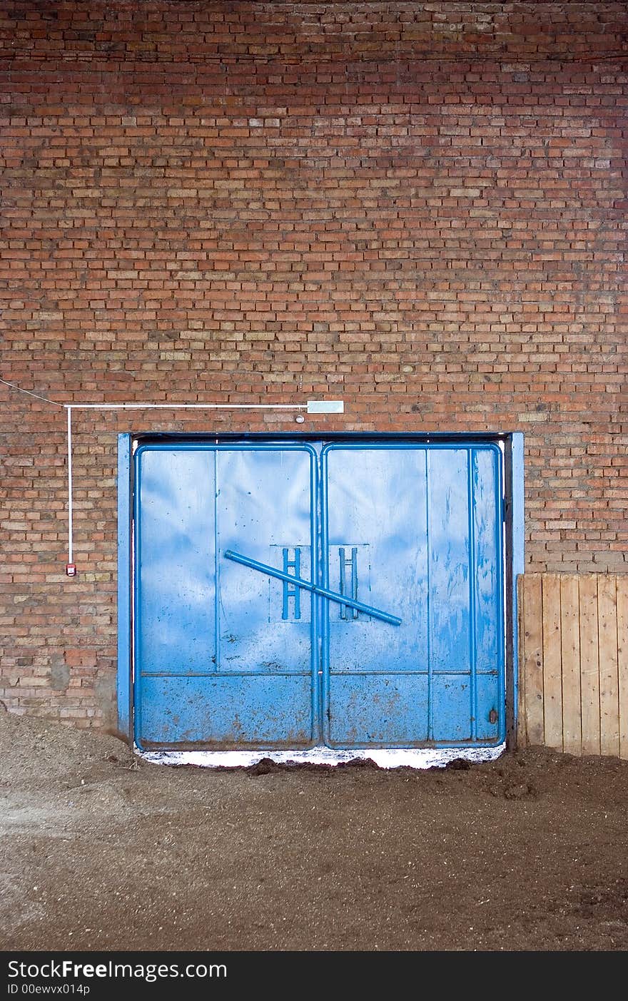 Blue gate in brick wall with desk