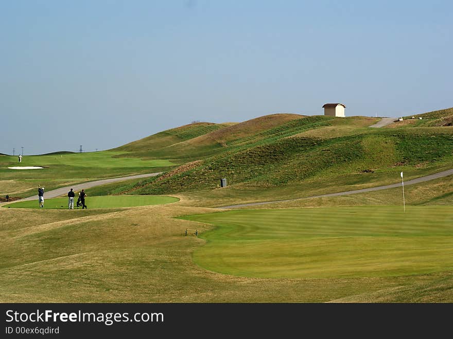 Photo of green golf course with landscape hill background. Photo of green golf course with landscape hill background