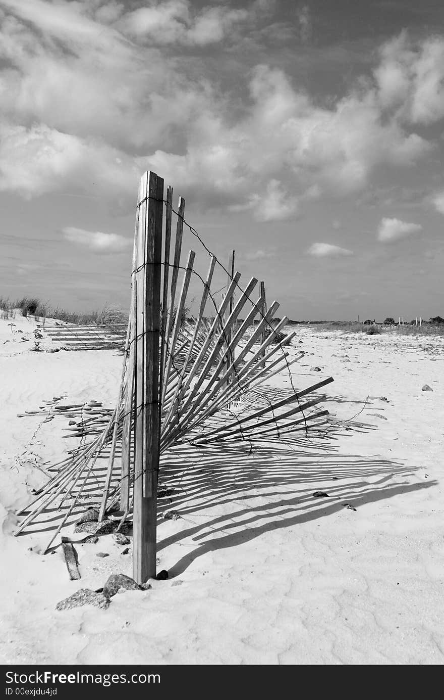 A dilapitated sand fence collapses into the dunes of Daytona Beach Inlet