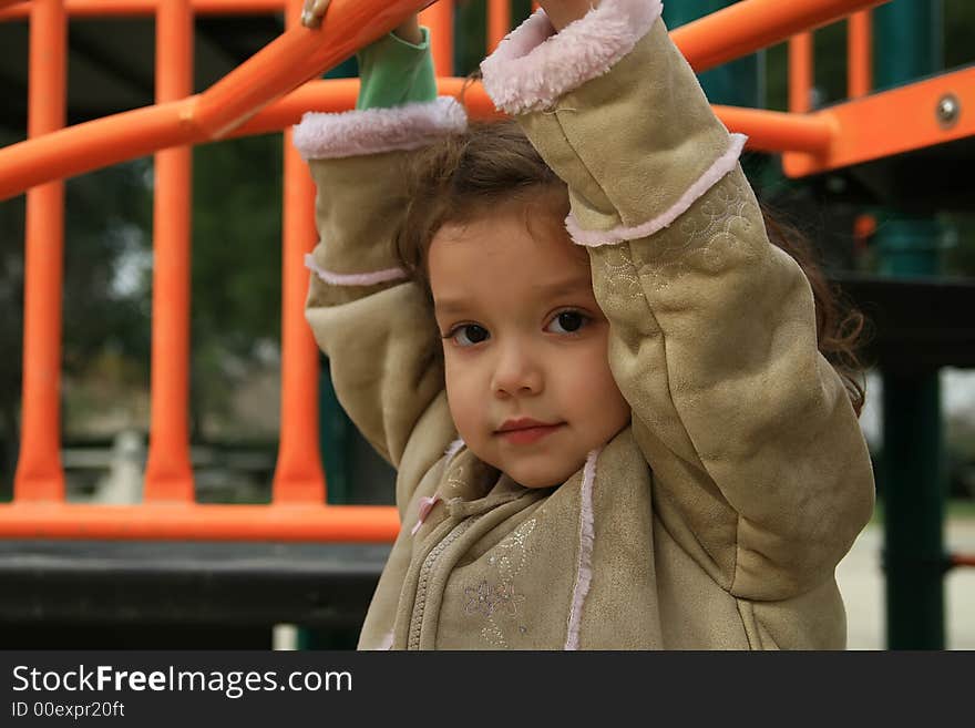 Cute child hanging from playground monkey bars. Cute child hanging from playground monkey bars