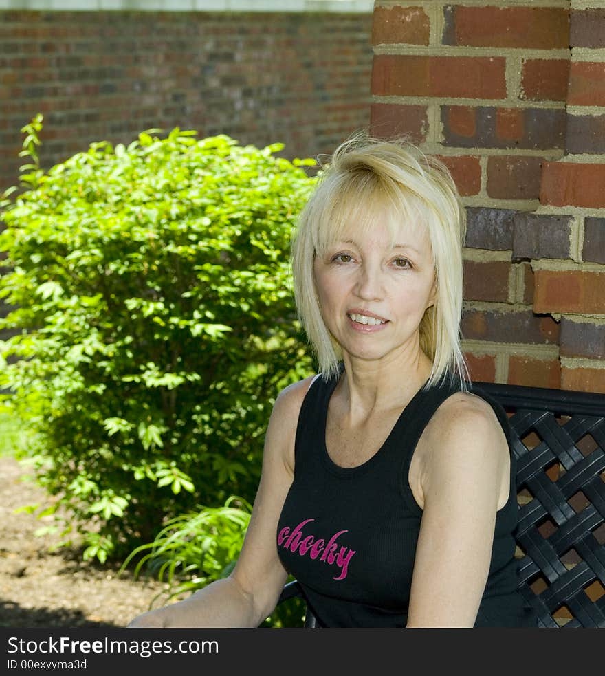 Cute petite blond relaxing on park bench. Cute petite blond relaxing on park bench