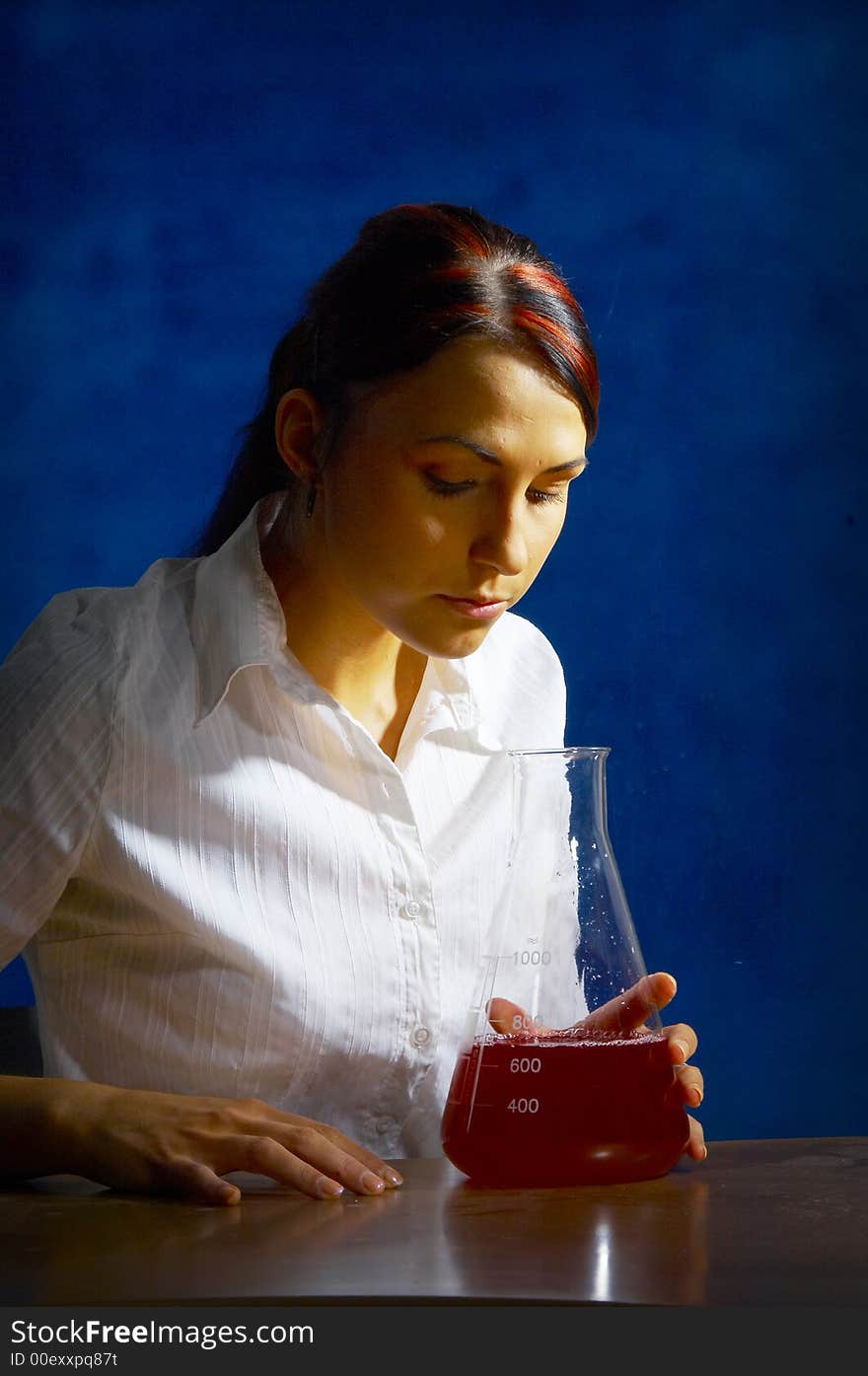 Beautiful female young scientist wearing glasses while doing a blood test