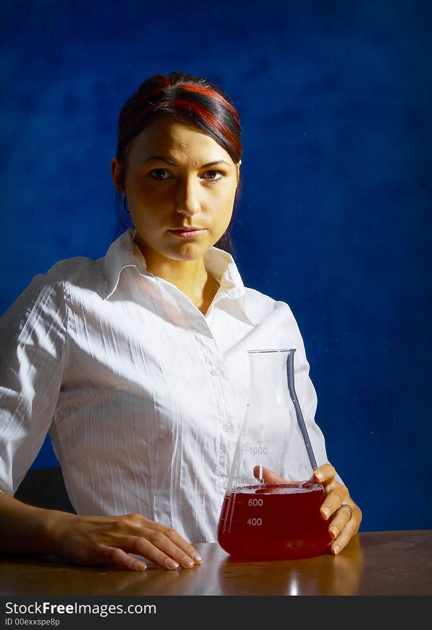 Beautiful female young scientist wearing glasses while doing a blood test