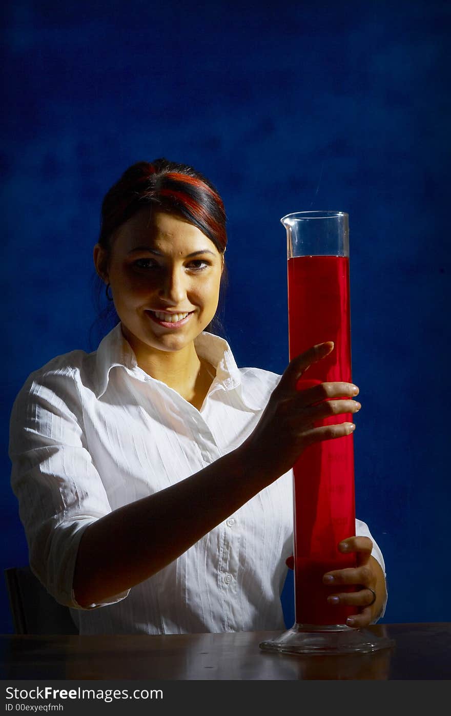 Beautiful female young scientist wearing glasses while doing a blood test