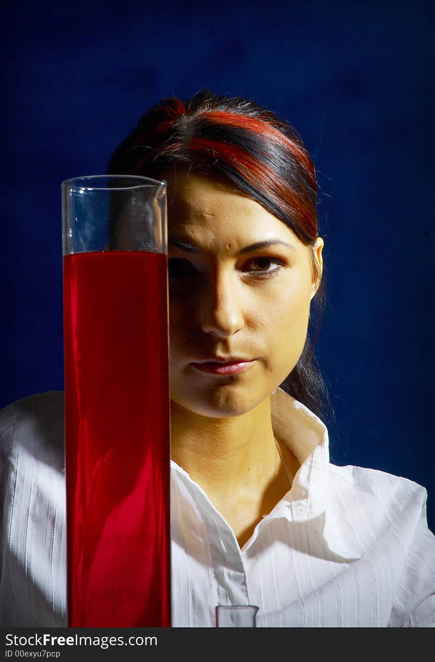 Beautiful female young scientist wearing glasses while doing a blood test