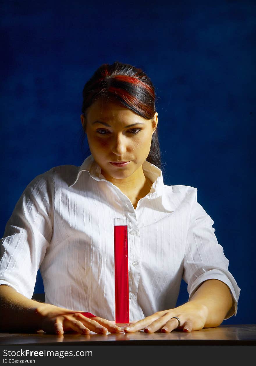 Beautiful female young scientist wearing glasses while doing a blood test