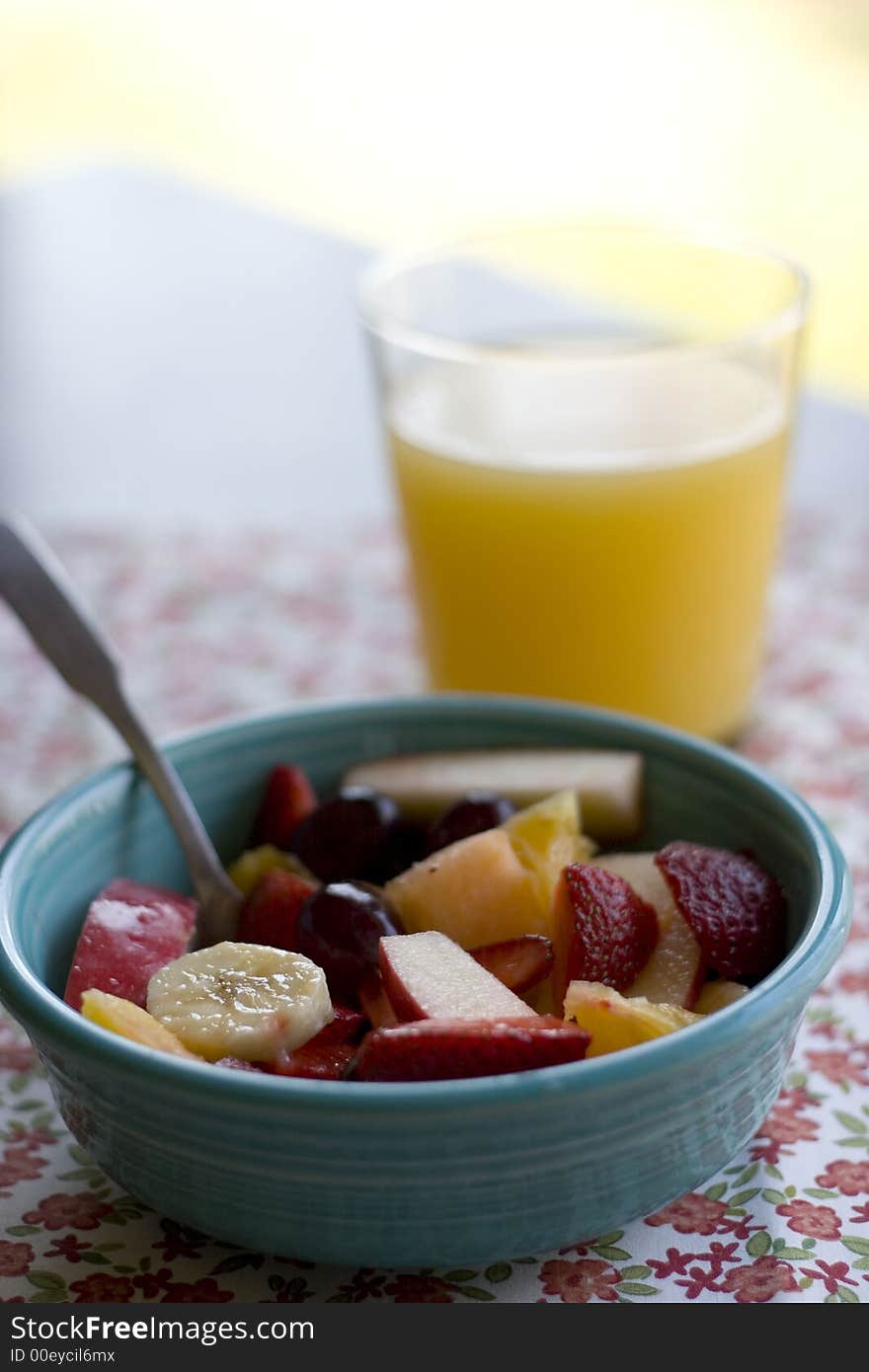 Bowl of mixed fruit salad with glass of juice. Bowl of mixed fruit salad with glass of juice