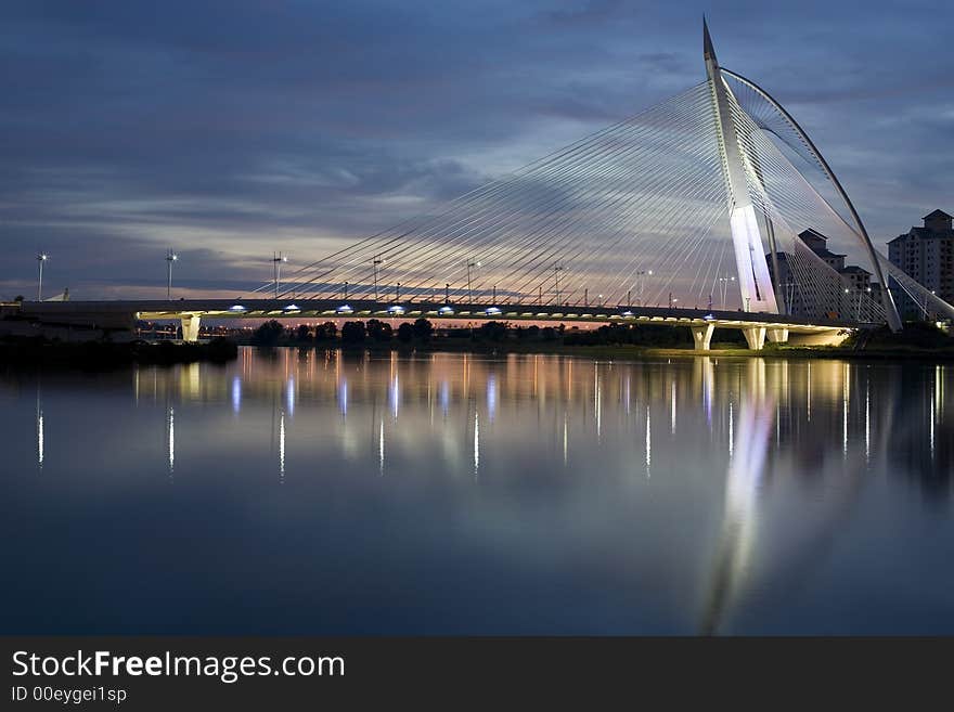 A bridge with a very unique design with a bench on the foreground