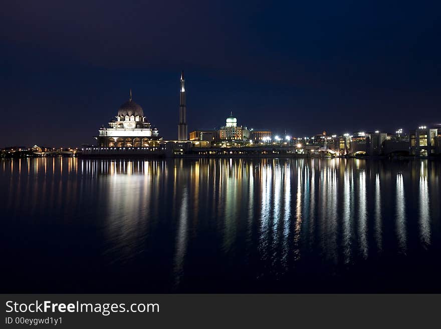 Night scene of a mosque bright lights reflected on the river