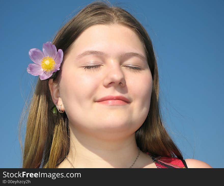 Pretty young girl with the flower in the hair