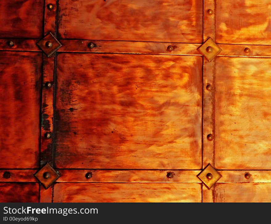 Coppery metal wall texture with rivets, background. Coppery metal wall texture with rivets, background