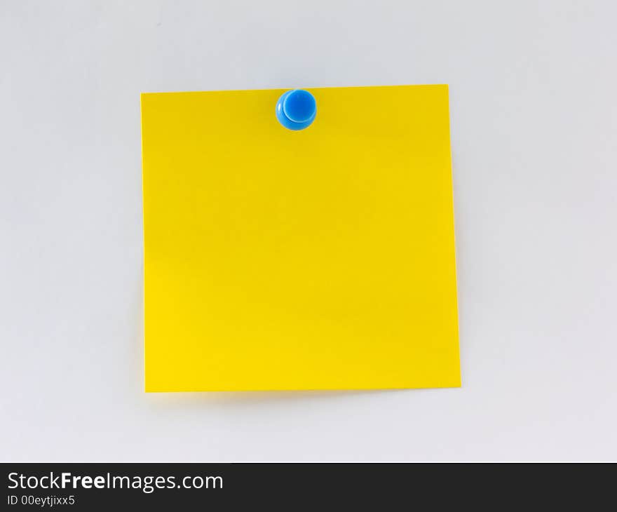 Blank yellow note pinned to a wall. Blank yellow note pinned to a wall