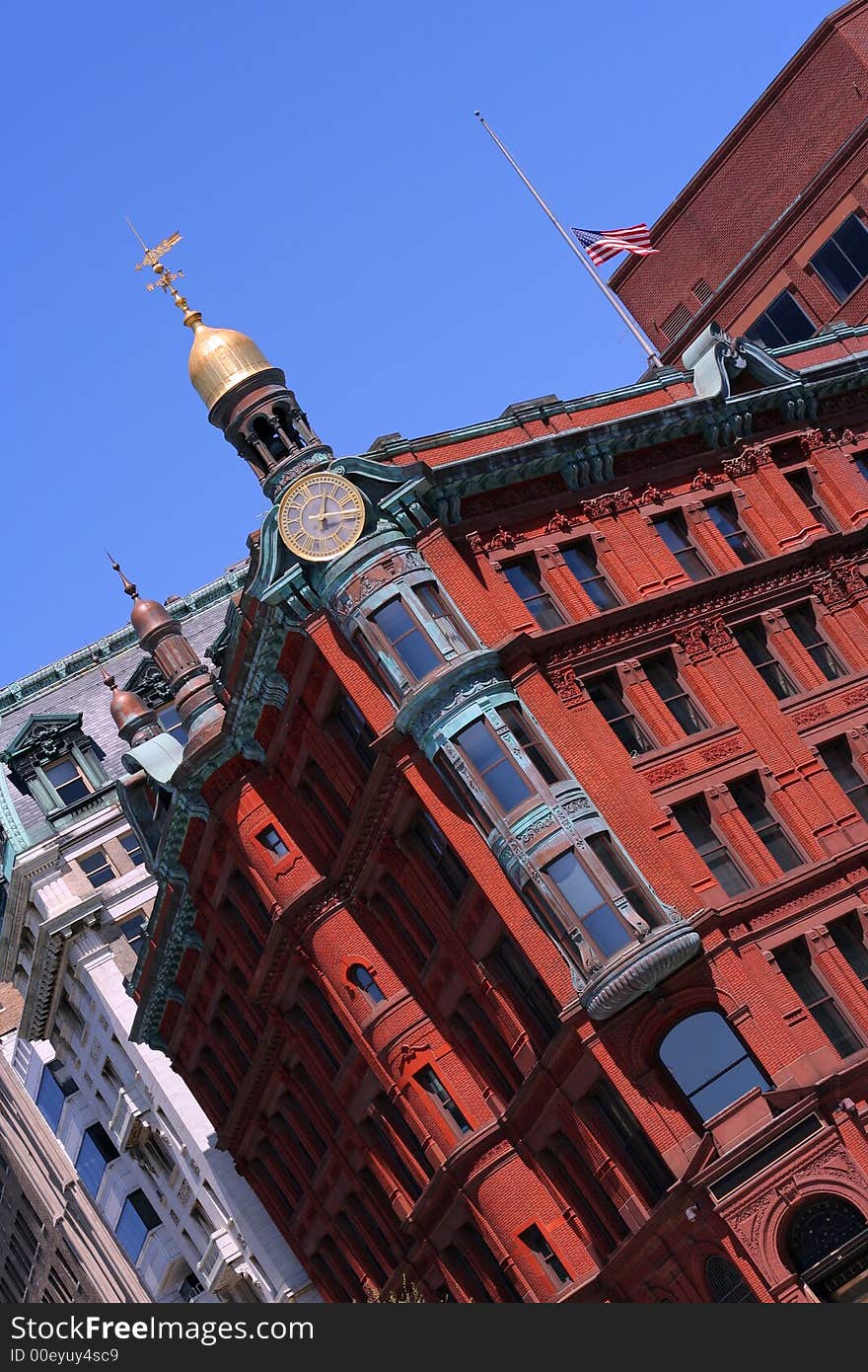 Tilted elegant office or apartment building with a clock and a small golden dome. Tilted elegant office or apartment building with a clock and a small golden dome.