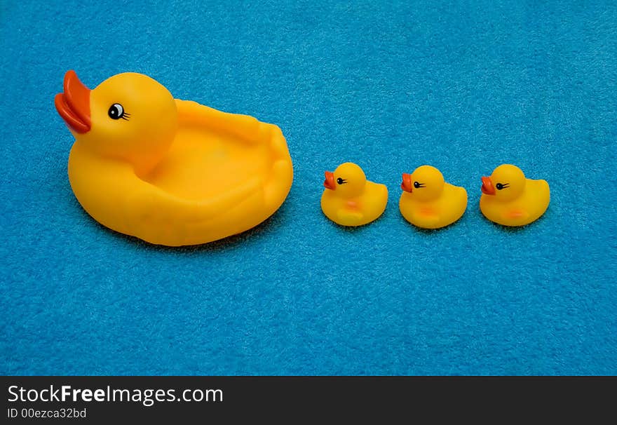 Three ducklings and a duck on blue background