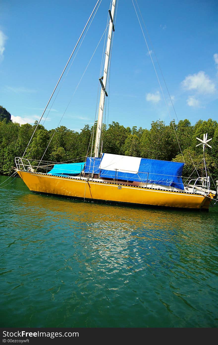 A catamaran anchored at the famous Kilim Geo-forest, Langkawi Island, Malaysia in clear water and mangrove forest as background. A catamaran anchored at the famous Kilim Geo-forest, Langkawi Island, Malaysia in clear water and mangrove forest as background.