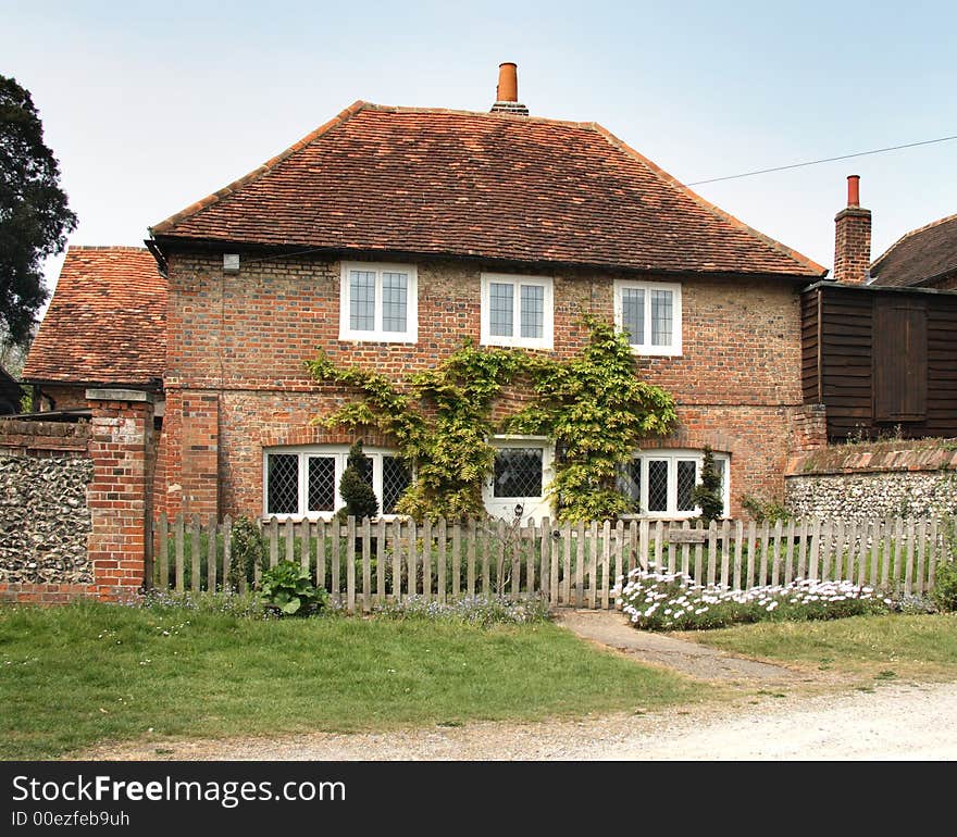 Red BrickVillage House in Rural England with a Brick and Flint Wall to the side. Red BrickVillage House in Rural England with a Brick and Flint Wall to the side