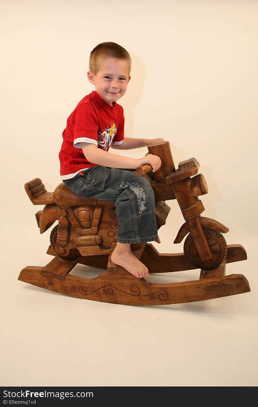 Young boy sat on a rocking motorbike. Young boy sat on a rocking motorbike